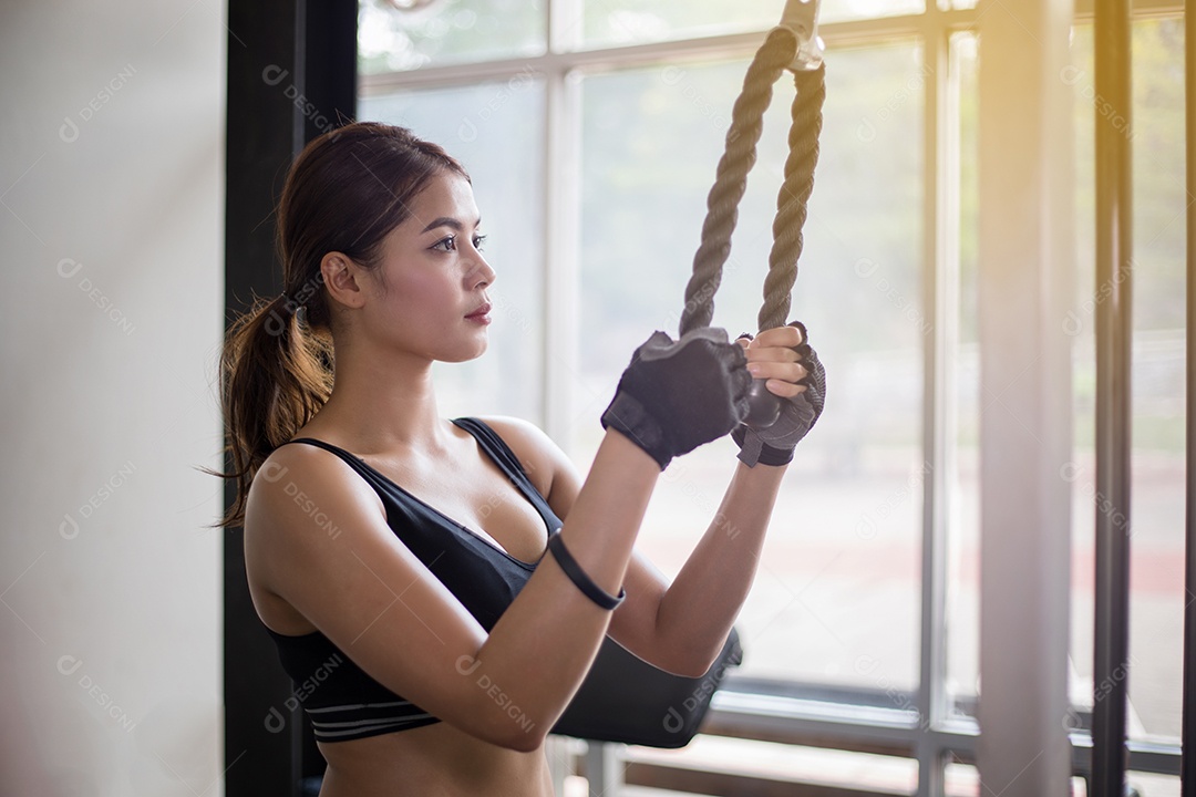 Mulher apto muscular exercitando a construção de músculos e fitness mulher fazendo exercícios no ginásio