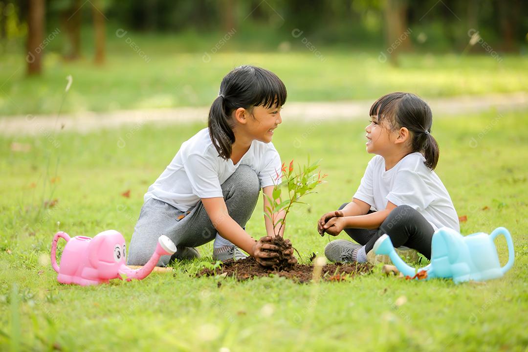 Meninas bonitinhas asiáticas regando as plantas que foram plantadas