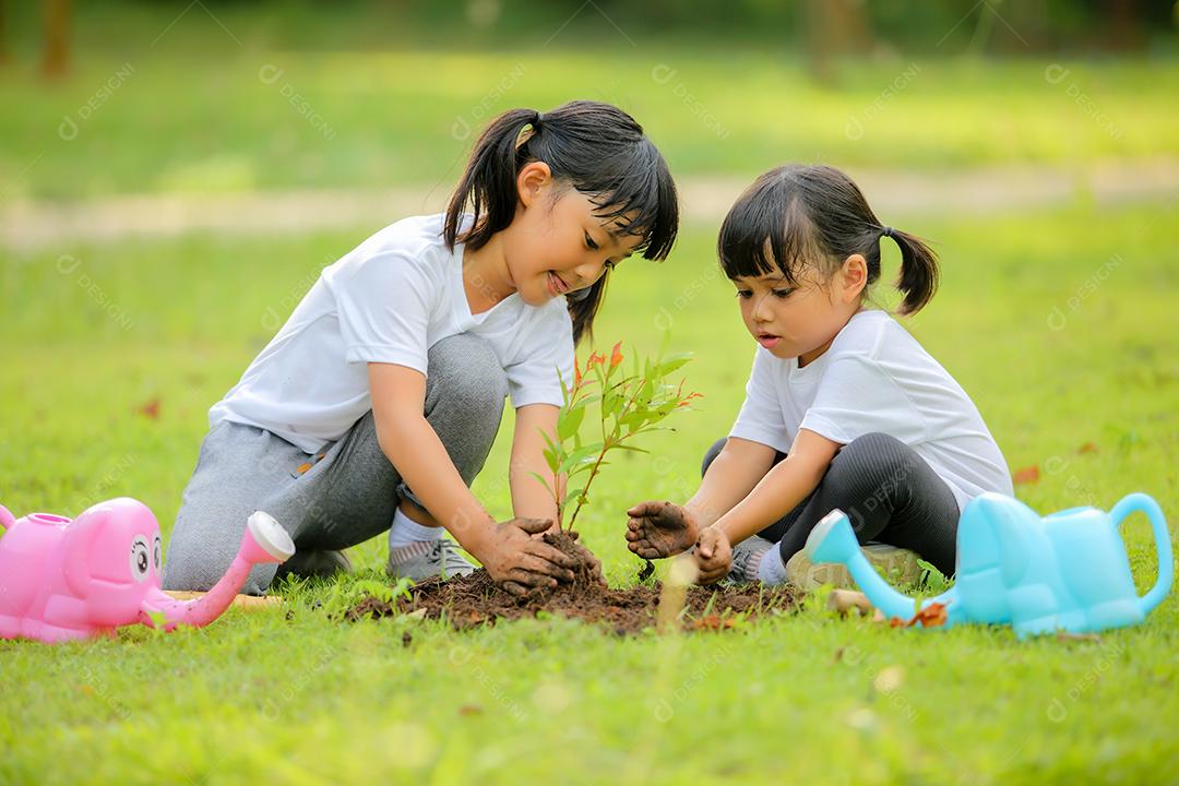 Meninas bonitinhas asiáticas regando as plantas que foram plantadas