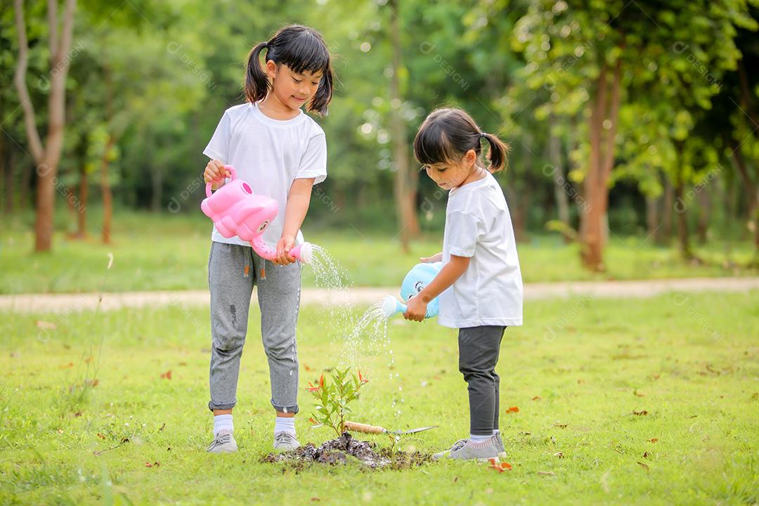 Meninas bonitinhas asiáticas regando as plantas que foram plantadas