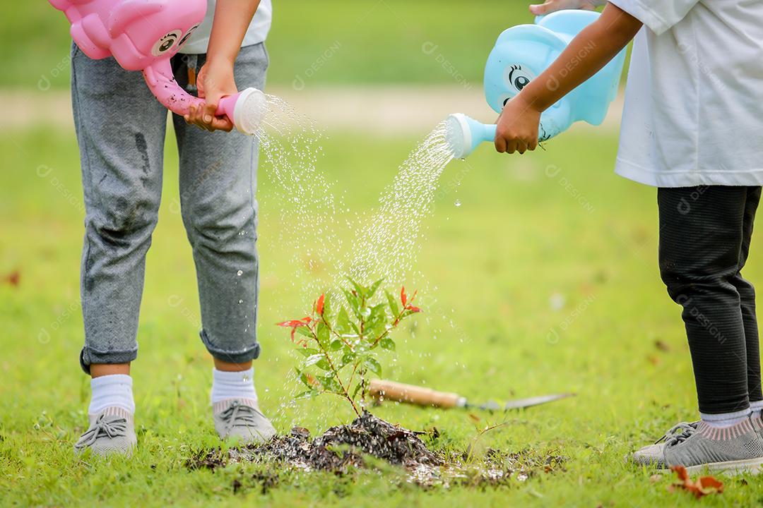 Meninas bonitinhas asiáticas regando as plantas que foram plantadas