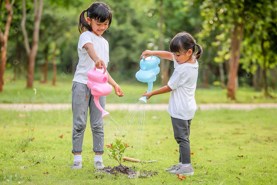 Meninas bonitinhas asiáticas regando as plantas que foram plantadas
