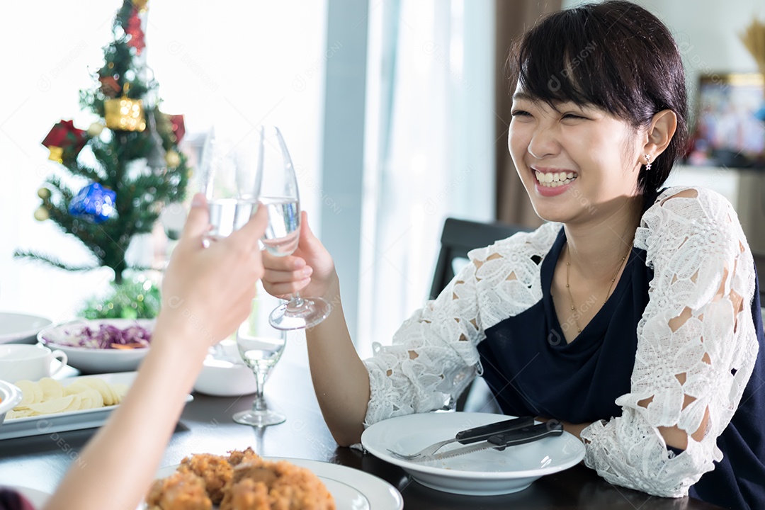 Casal jovem asiático desfrutando de um jantar romântico bebidas à noite enquanto está sentado à mesa de jantar na cozinha juntos