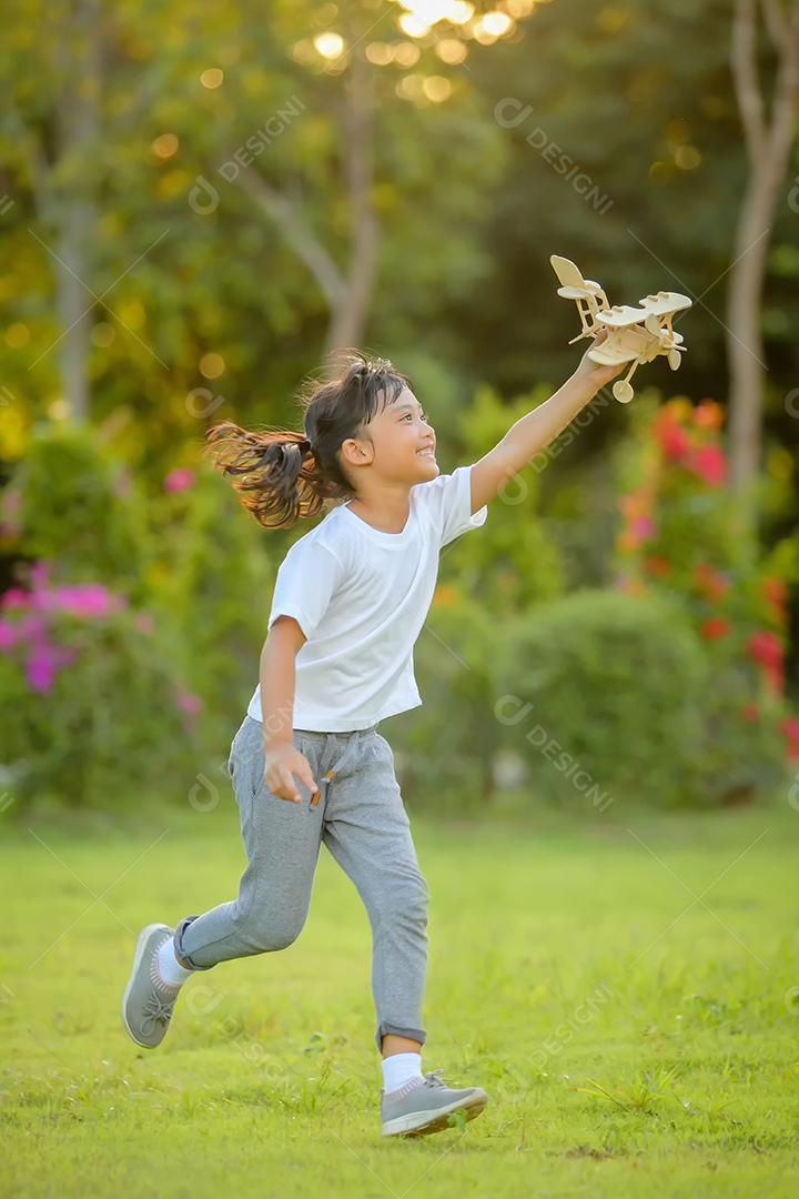 Meninas bonitinhas asiáticas brincando com avião de brinquedo na natureza no parque