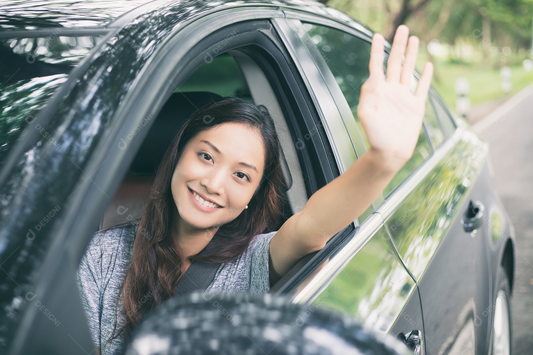 Linda mulher asiática sorrindo e se divertindo dirigindo um carro na estrada para viajar