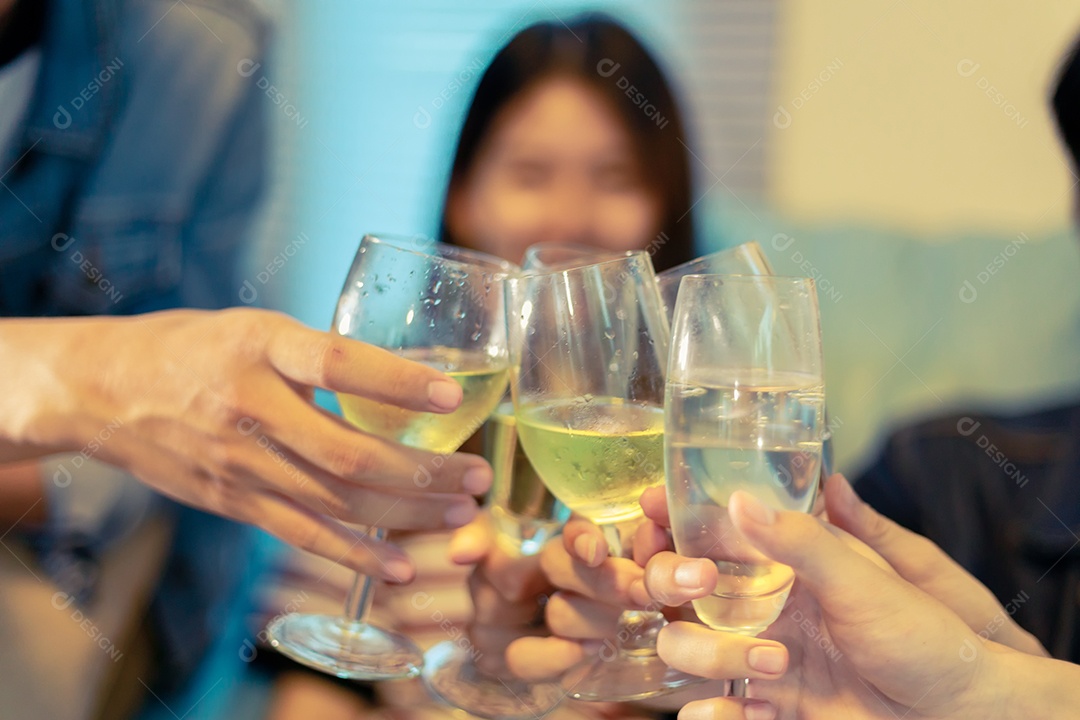 Grupo asiático de amigos festejando com bebidas alcoólicas de cerveja e pessoas do grupo com champanhe dançando na festa.