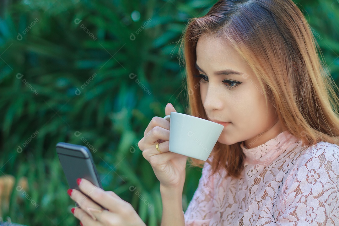 Mulher de negócios asiática está trabalhando usando celular e telefone inteligente de toque para comunicação e bebendo café ao ar livre