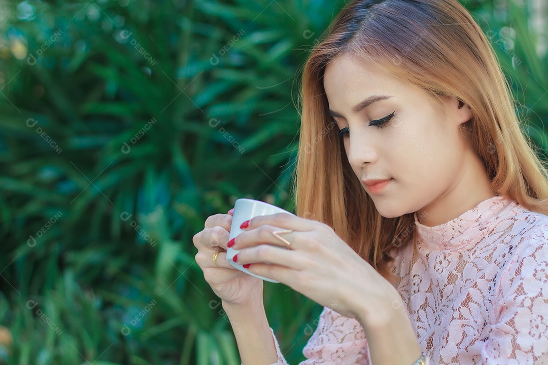 Mulher de negócios asiáticos está trabalhando e bebendo café ao ar livre