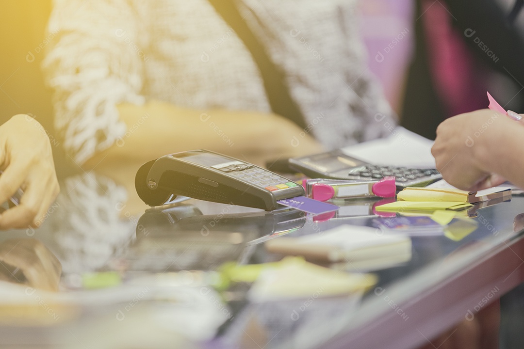 Mulher de negócios asiáticos usam máquina de cartão de crédito para pagamento em cafeteria e supermercado