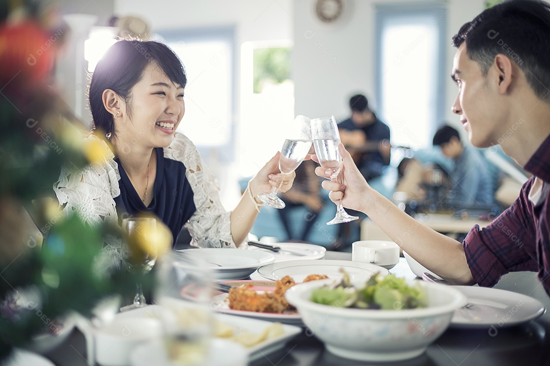 Casal jovem asiático desfrutando de um jantar romântico bebidas à noite enquanto está sentado à mesa de jantar na cozinha juntos,