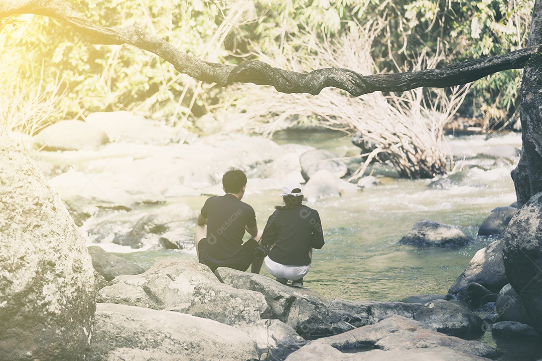casal sentados juntos na cachoeira com felicidade e romance.