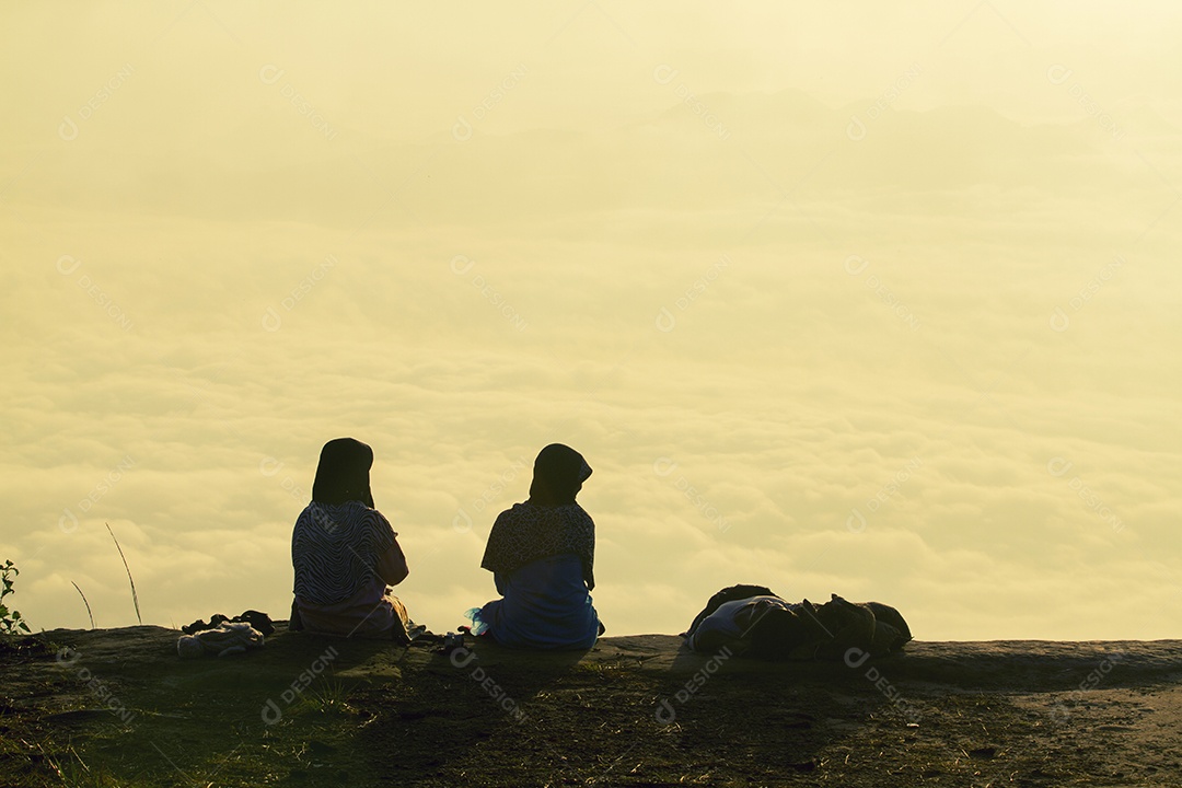 Casal romântico e sentar e assistir o nascer do sol na montanha.