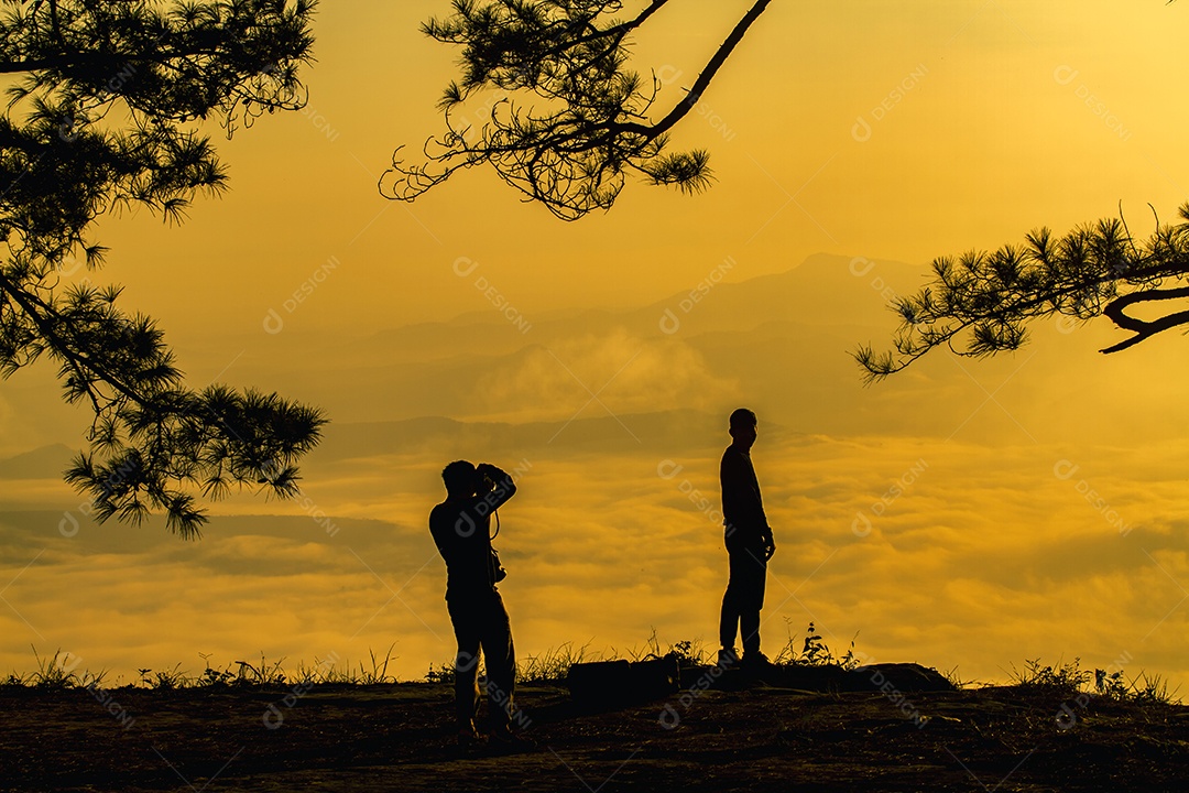 silhueta dois homens ásia com mochila tirando uma foto no topo das montanhas, foco suave