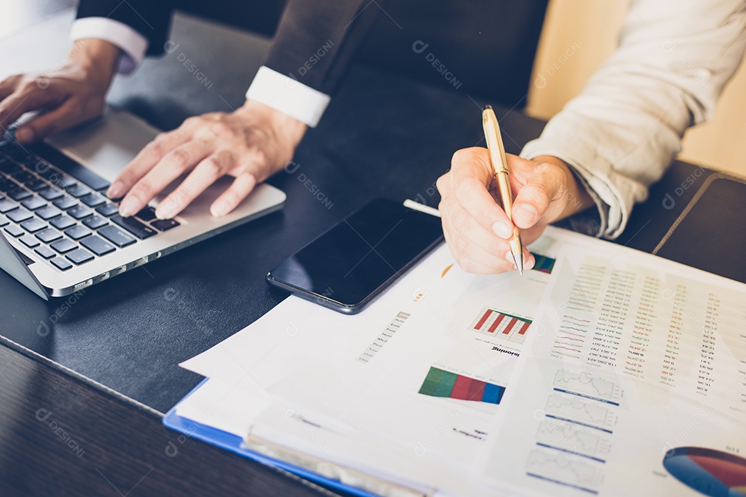 Mulheres de negócios asiáticas segurando uma caneta e documentos de análise