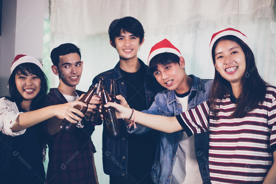 Grupo asiático de amigos festejando com cerveja alcoólica