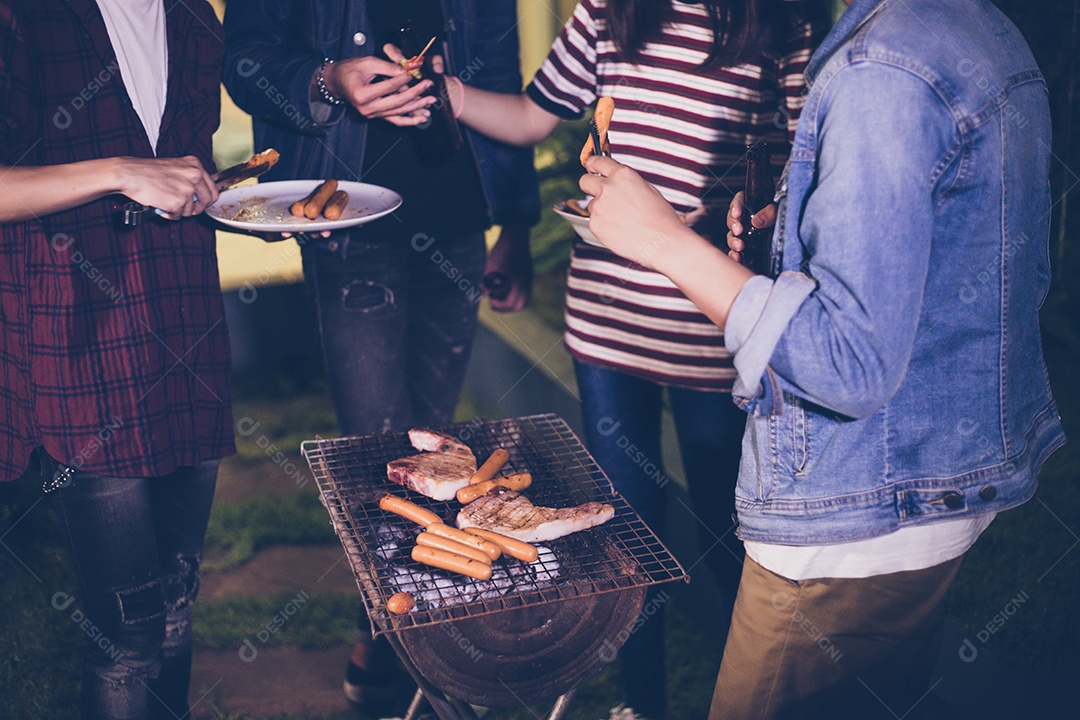 Grupo asiático de amigos fazendo churrasco no jardim ao ar livre rindo