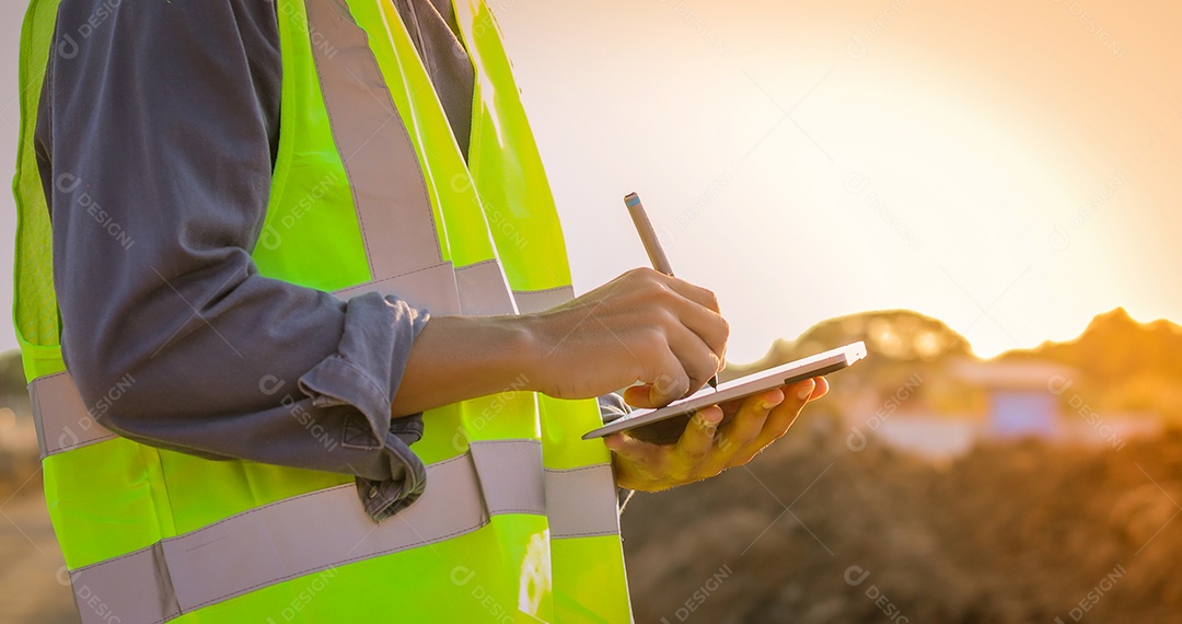 Engenheiro asiático com capacete de segurança usando computador tablet pc inspecionando