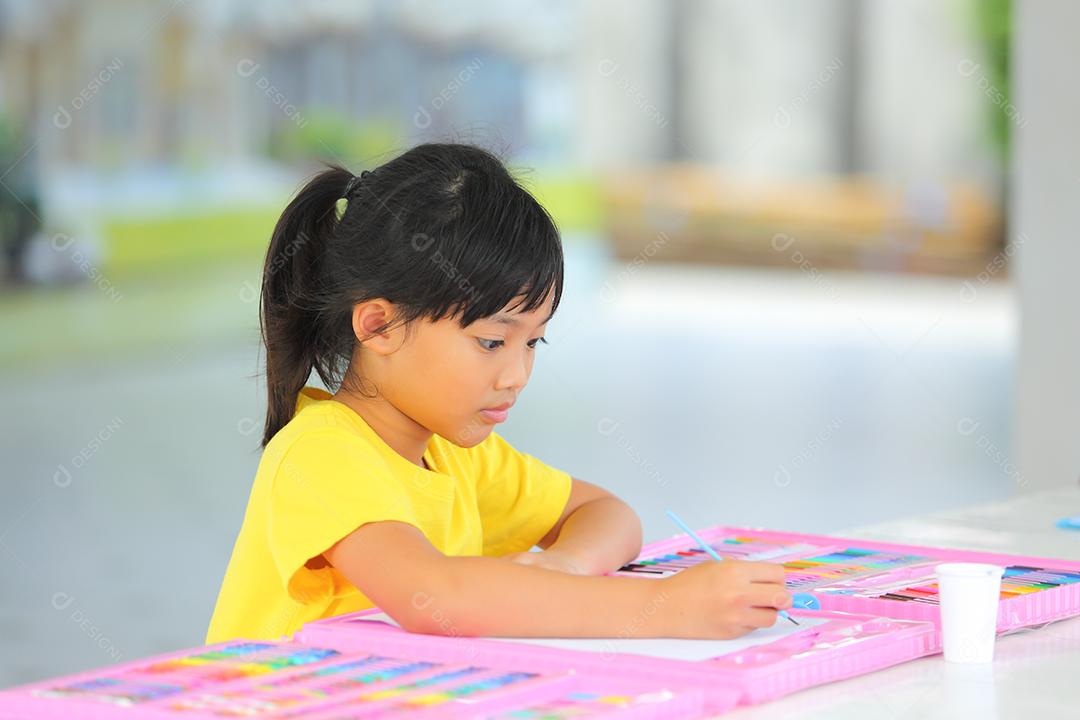 Menina asiática fazendo uma pintura com espaço de cópia.