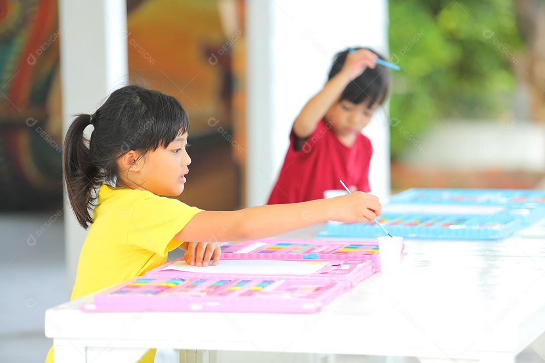 Menina asiática fazendo uma pintura com espaço de cópia.