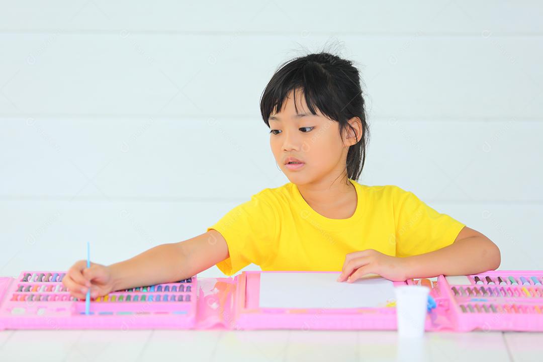 Menina asiática fazendo uma pintura com espaço de cópia.