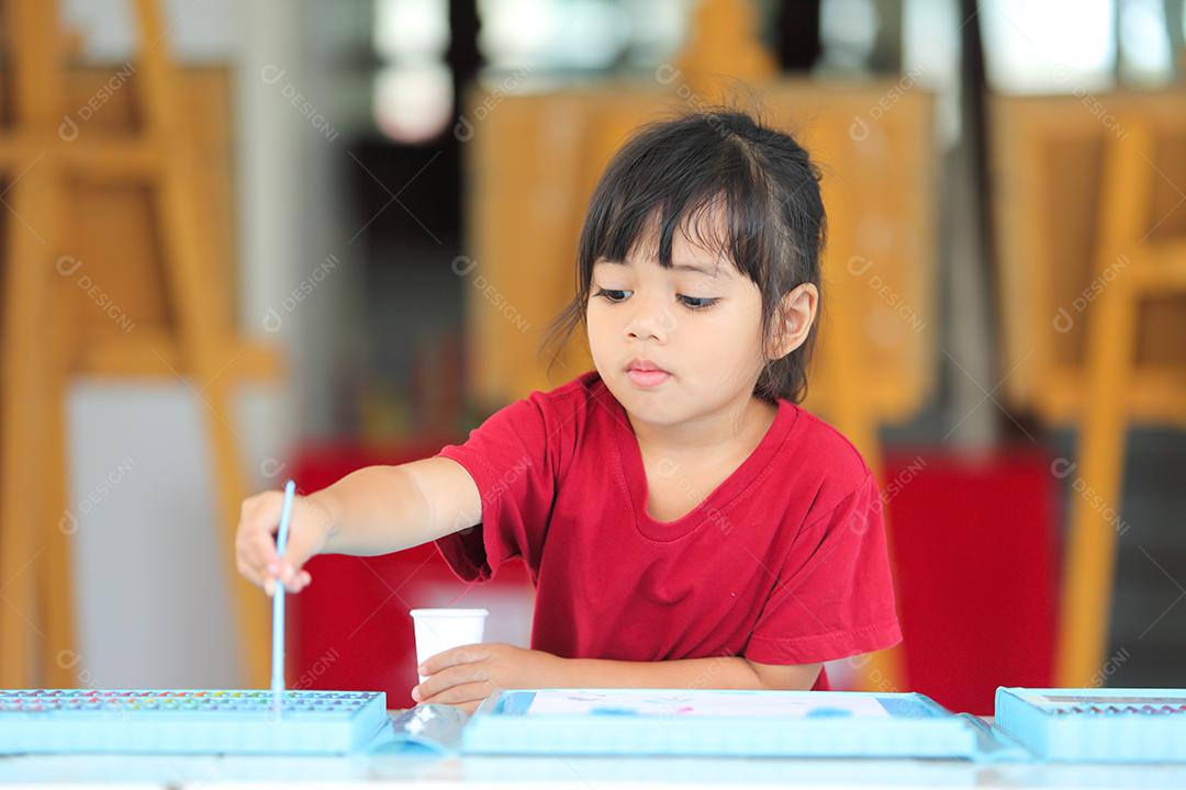 Menina asiática fazendo uma pintura com espaço de cópia.