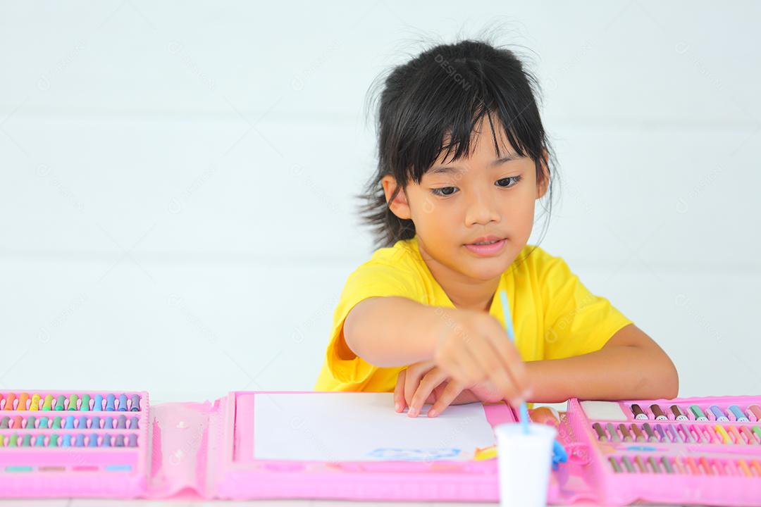 Menina asiática fazendo uma pintura com espaço de cópia.