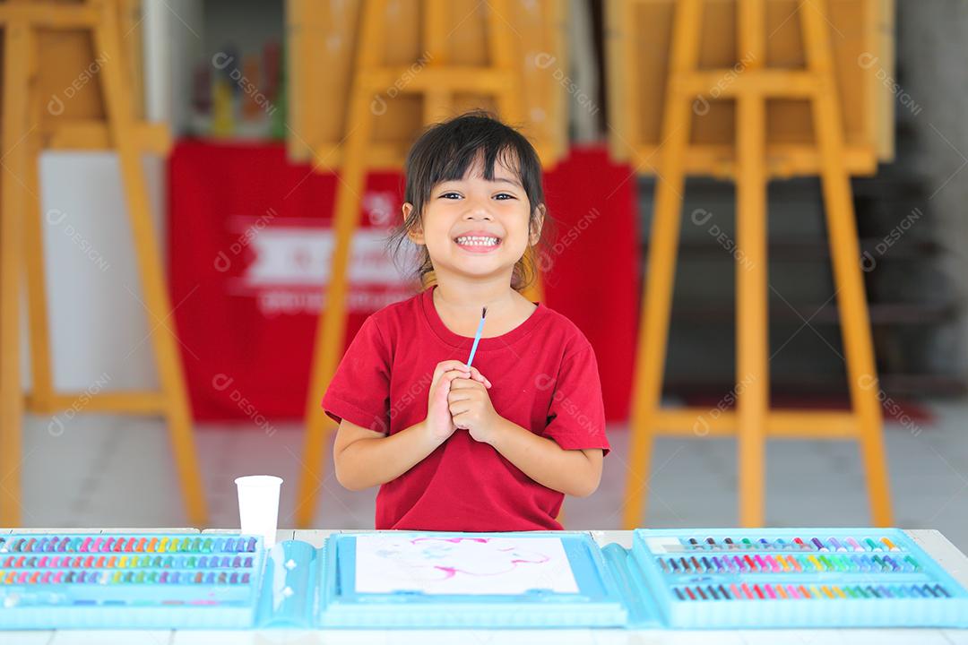Menina asiática fazendo uma pintura com espaço de cópia.