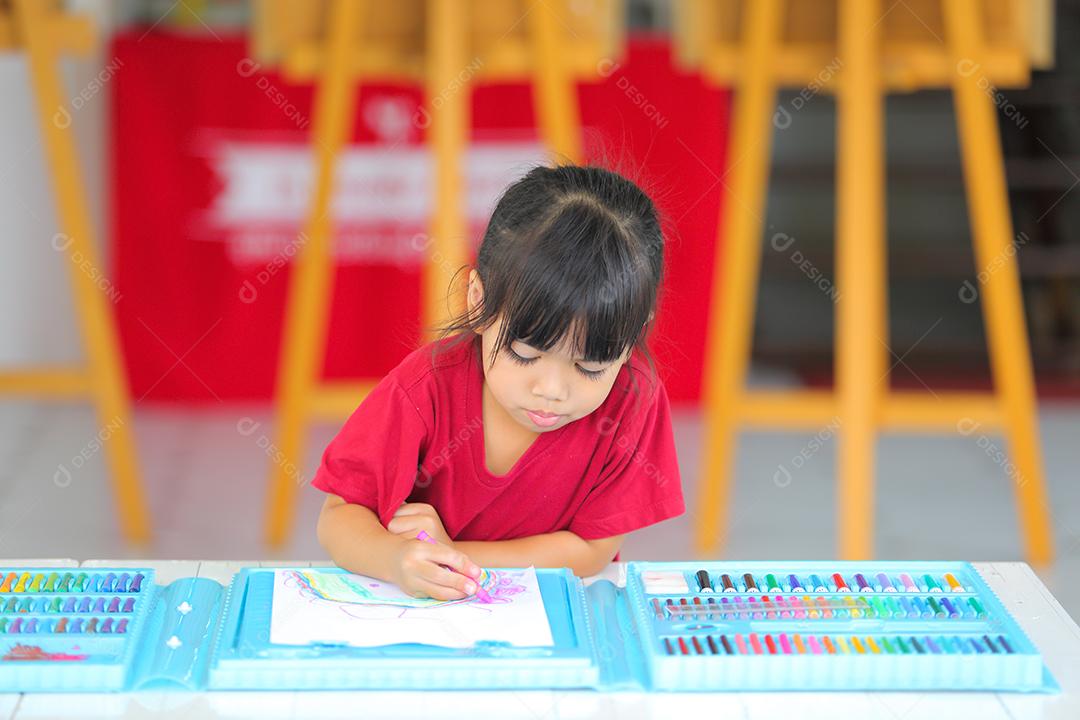 Menina asiática fazendo uma pintura com espaço de cópia.