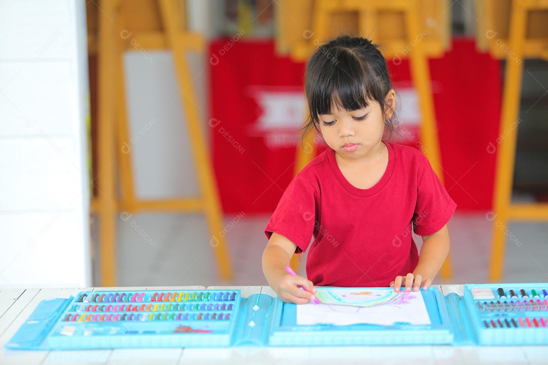 Menina asiática fazendo uma pintura com espaço de cópia.