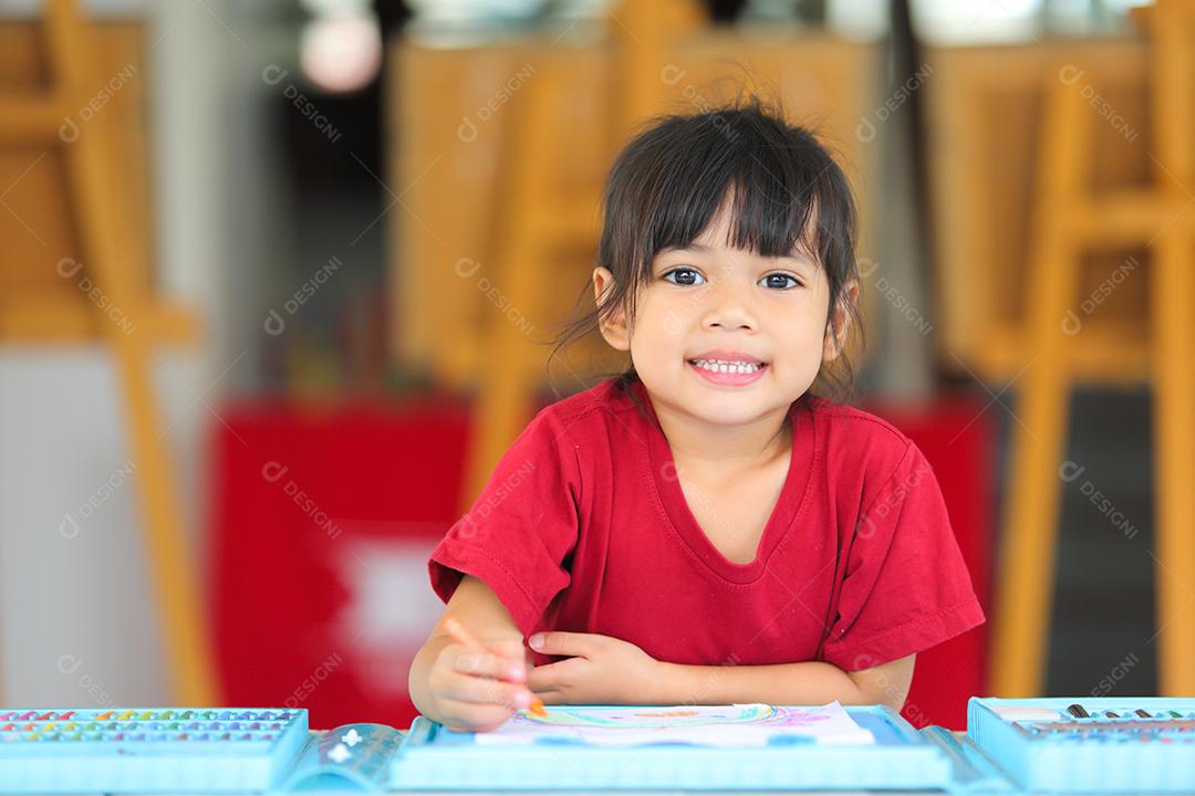 Menina asiática fazendo uma pintura com espaço de cópia.