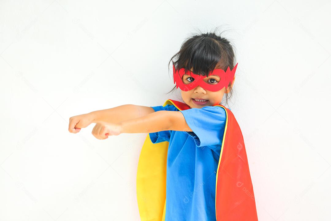 Uma menina bonitinha com máscara vestida e vestindo e capa de criança super-herói.