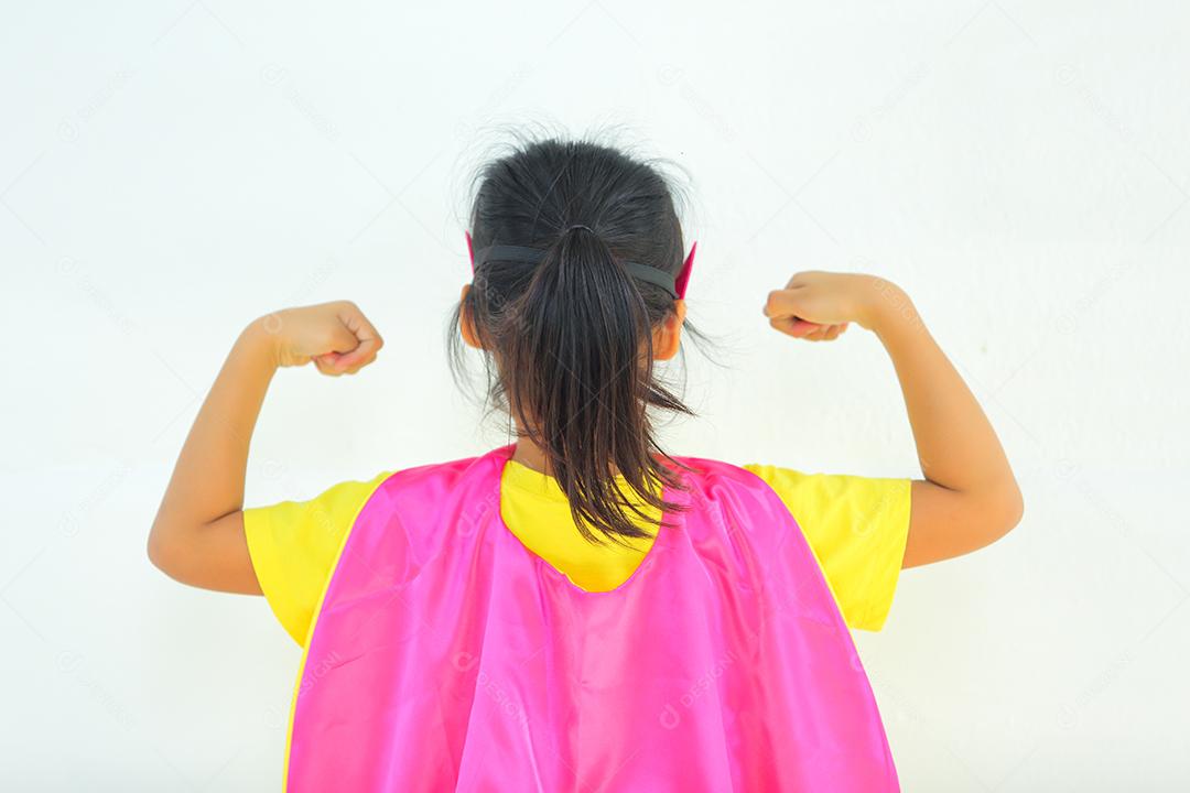Uma menina bonitinha com máscara vestida e vestindo e capa de criança super-herói.