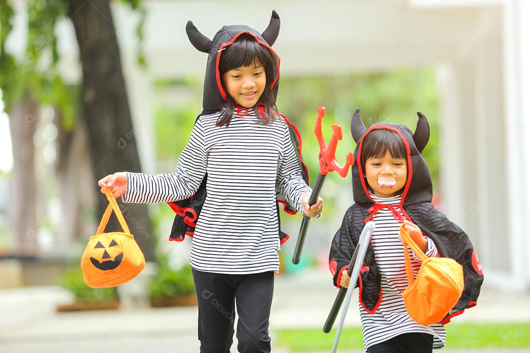 Conceito de Halloween, crianças vestidas com fantasias temáticas.