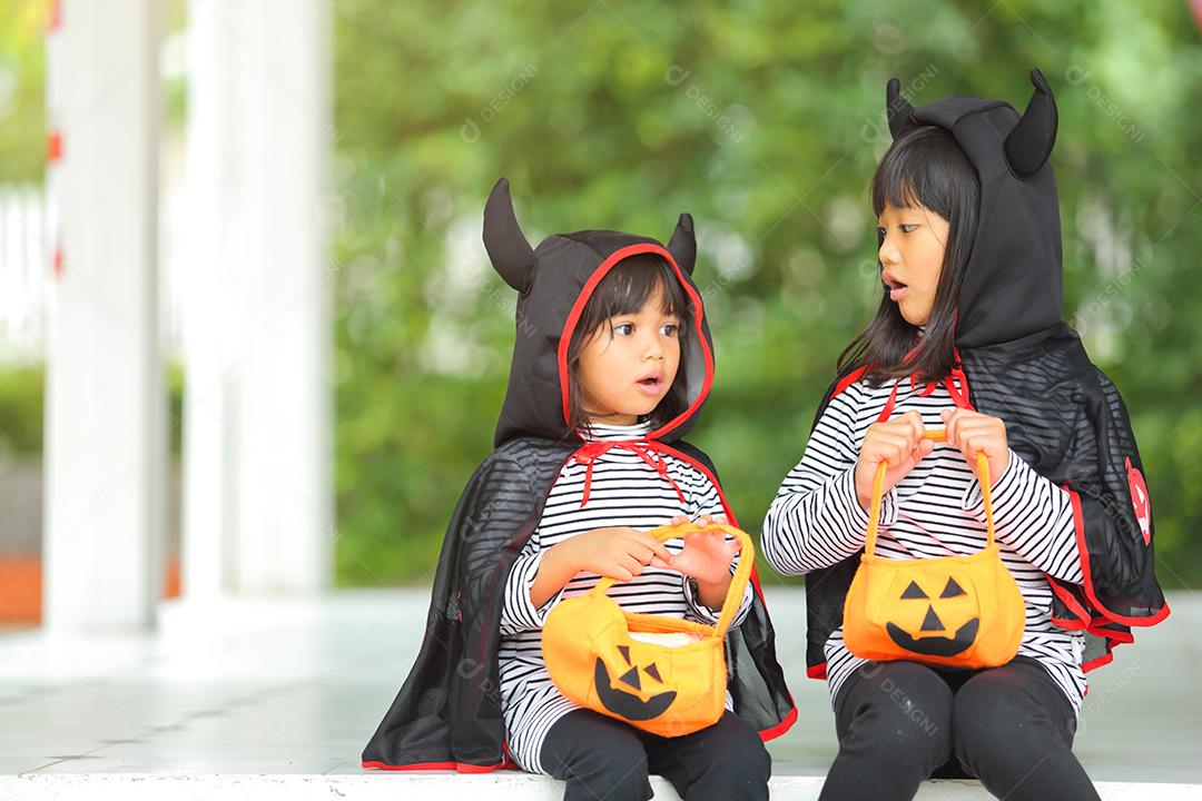 Conceito de Halloween, crianças vestidas com fantasias temáticas.