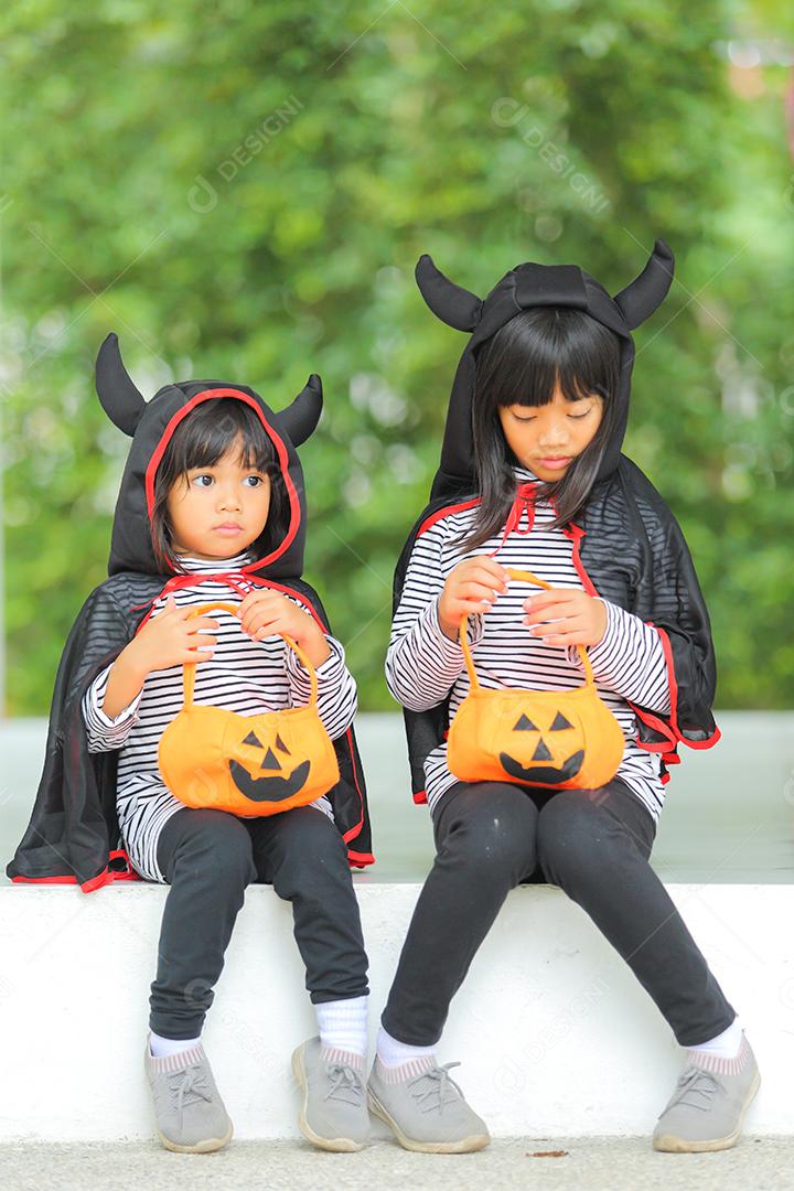 Conceito de Halloween, crianças vestidas com fantasias temáticas.