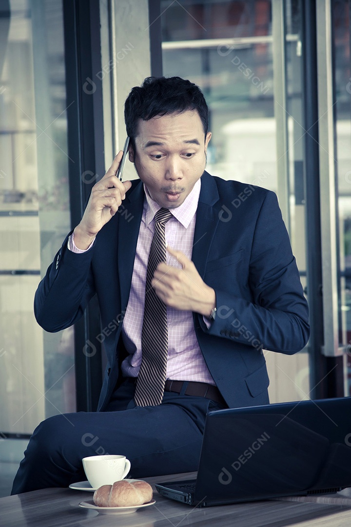 Jovem empresário falando no celular no café
