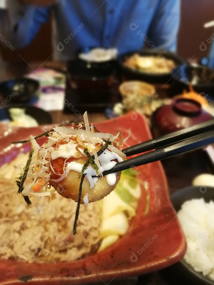 Detalhe de takoyaki, bola de takoyaki presa com pauzinho