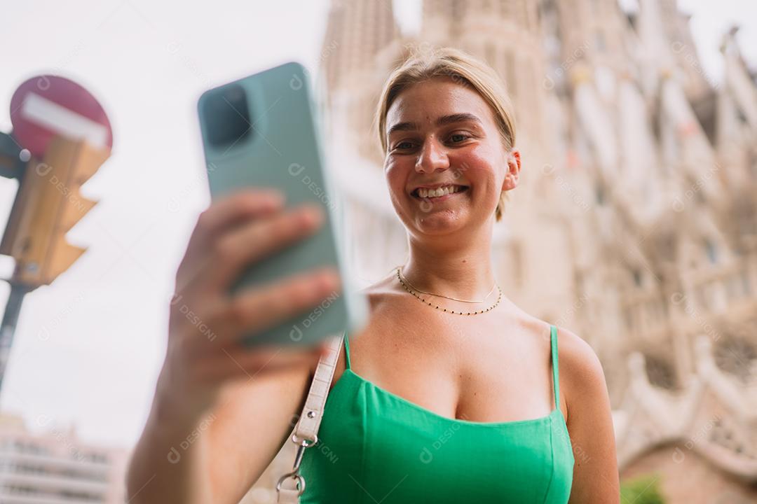 Feliz usuário de telefone turístico feminino em Barcelona, ​​Espanha, usando smartphone.