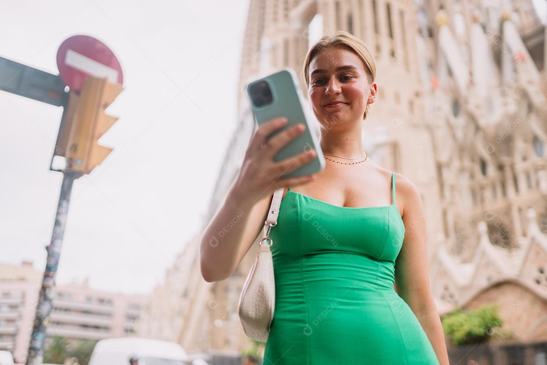 Feliz usuário de telefone turístico feminino em Barcelona, ​​Espanha, usando smartphone.