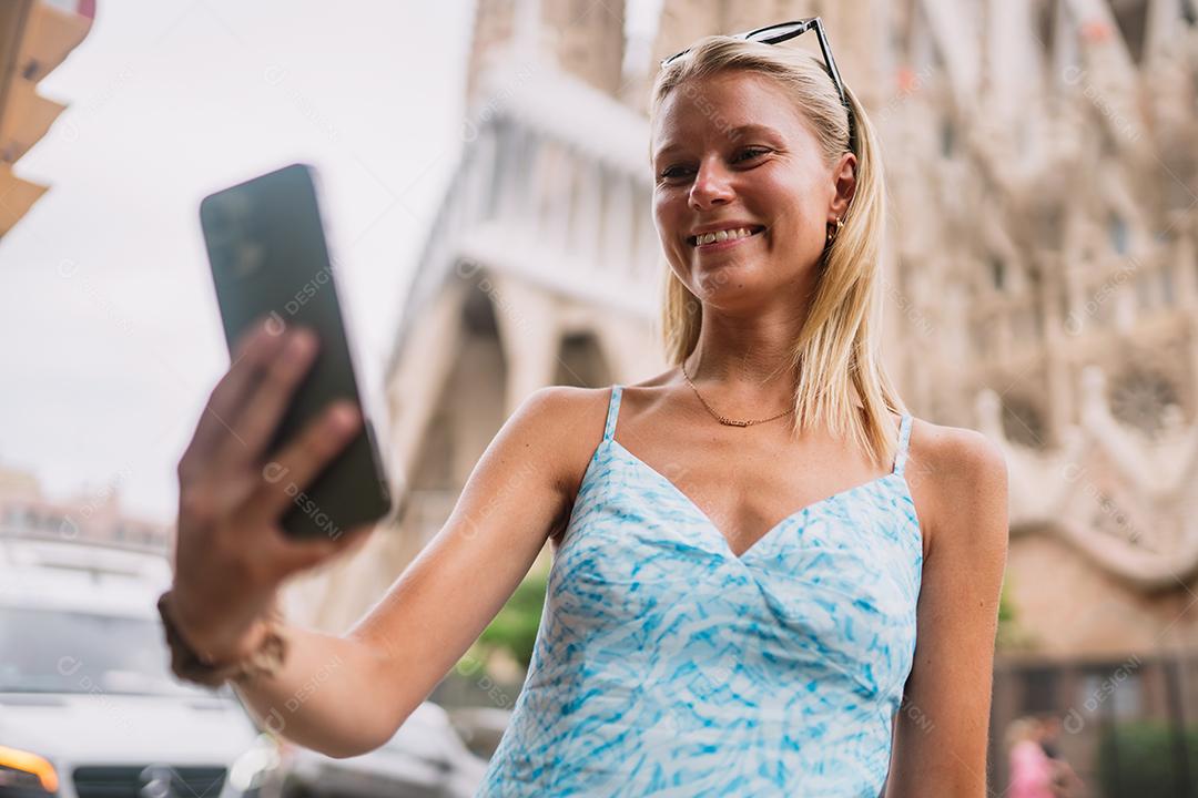 Feliz usuário de telefone turístico feminino em Barcelona, ​​Espanha, usando smartphone.