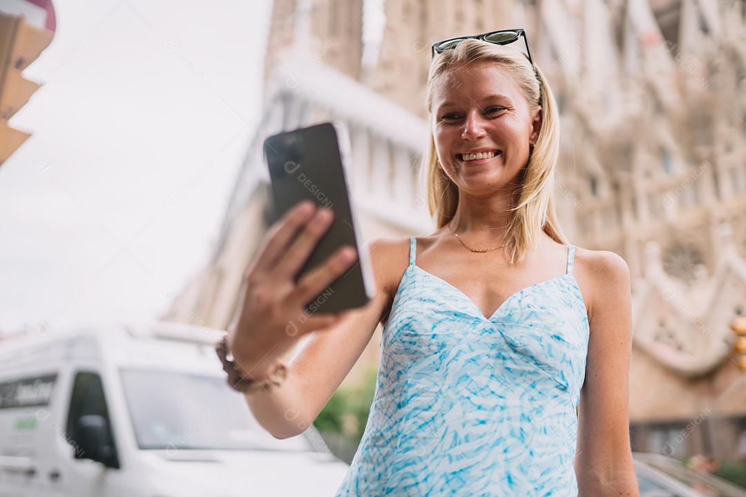 Feliz usuário de telefone turístico feminino em Barcelona, ​​Espanha, usando smartphone.