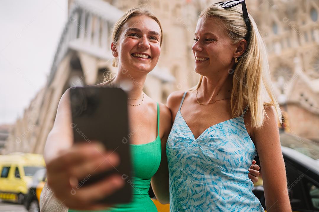 Amigas felizes aproveitando sua viagem em Barcelona segurando um mapa.