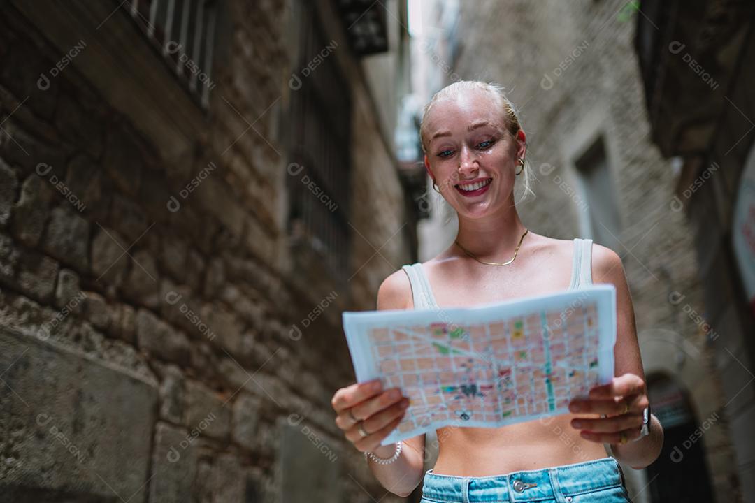 Usuário de mapas turísticos femininos andando no beco da cidade velha usando um mapa