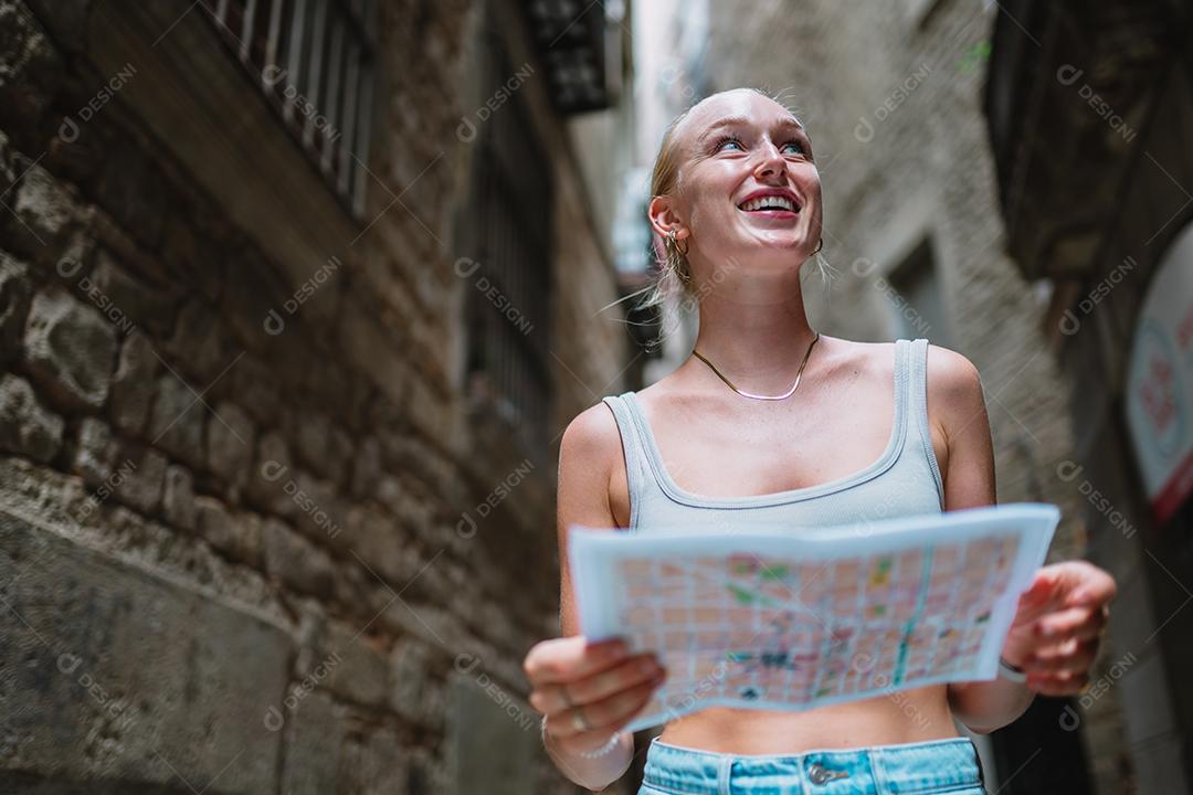 Usuário de mapas turísticos femininos andando no beco da cidade velha usando um mapa