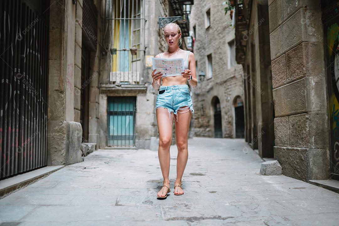 Usuário de mapas turísticos femininos andando no beco da cidade velha usando um mapa