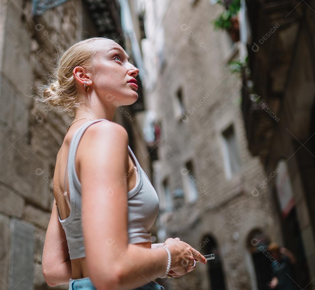 Feliz turista feminina para trás andando no beco da cidade velha.