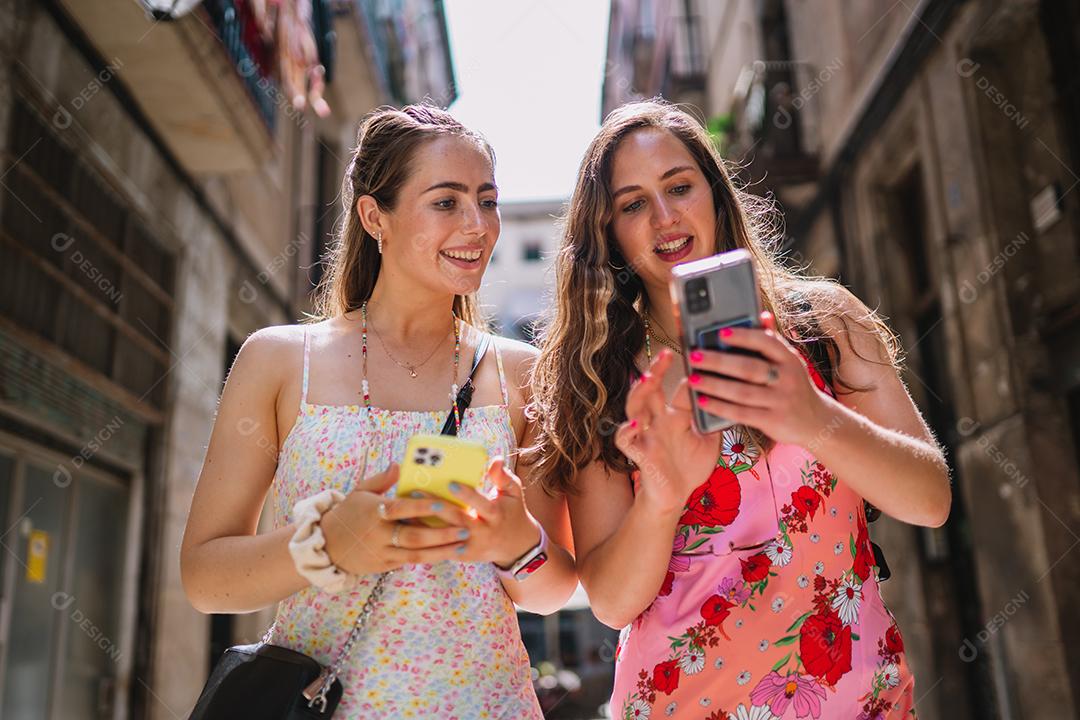Felizes turistas telefonam para usuários andando no beco da cidade velha e você