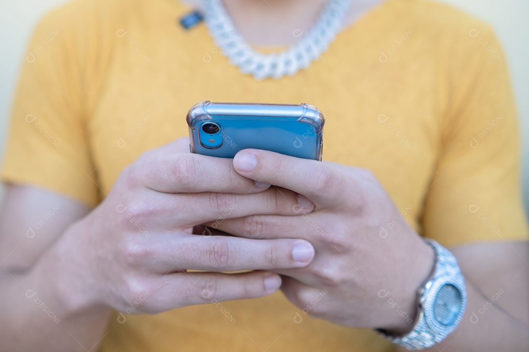 Aproximação de um jovem feliz usando um dispositivo smartphone moderno - Hipster digitando mensagem sms no telefone
