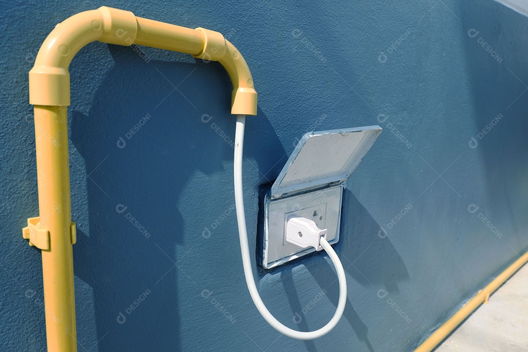 O plugue está conectado a uma tomada na parte externa da casa