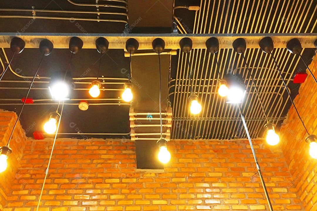 Decorar a sala com paredes de tijolos com lâmpadas é lindo.